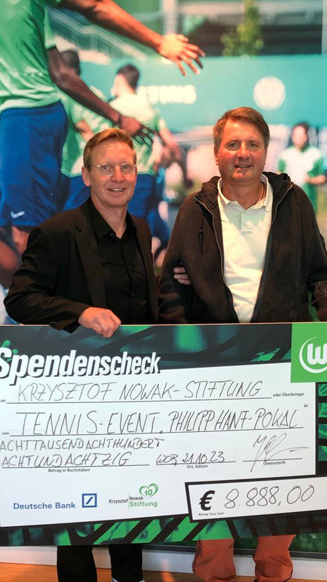 Roy Präger nimmt Spendenscheck für die Krzysztof-Nowak-Stiftung vom VfL Wolfsburg entgegen.